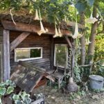 A small wooden structure with a window and a bench inside.