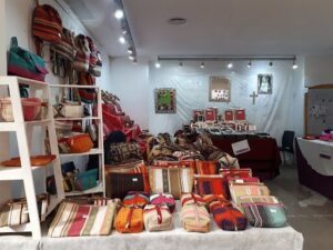 A table full of colorful bags and purses.