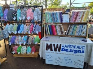 A table full of handmade hats and scarves for sale.