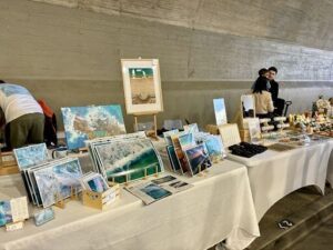 A table full of pictures and cards is set up for sale.