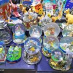 A table full of various glass balls and figurines, including a giraffe, a kangaroo, and a panda.