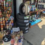 A tire with a sticker on it sits on the ground next to a table full of art supplies.