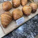 A tray of croissants with a sign that says "Croissantant" on it.
