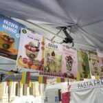 A variety of fruits and desserts are displayed on a tent, including bananas, apples, and strawberries.