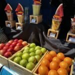 A variety of fruits are displayed on a table, including apples, oranges, and watermelon.
