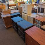 A variety of furniture, including dressers and chairs, are displayed in a room.