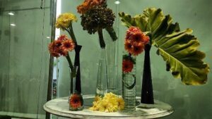 A vase filled with flowers sits on a table.