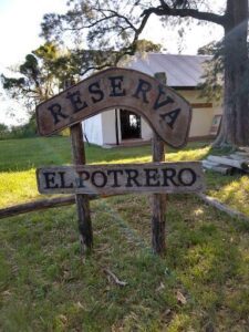A wooden sign with the words "Reserva El Potrero" written on it.