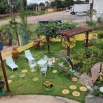A backyard with a patio set up, including chairs and tables, and a variety of decorative elements such as birds, fish, and a frog.