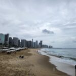 A beach scene with a city skyline in the background.