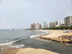 A beach scene with a city skyline in the background.