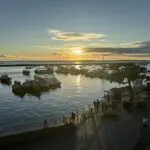 A beautiful sunset over the ocean with a group of people enjoying the view.