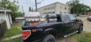 A black truck with the letters XTR on the front is parked in front of a building.