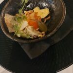 A bowl of food with a green plant on top.