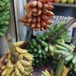 A bunch of bananas are displayed in a basket, with a sign nearby that reads "Anana."