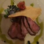 A close-up of a delicious steak with a side of salsa.