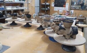 A collection of elephant-shaped vases are displayed on a table.