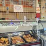 A deli counter with a sign that reads "oferta" and a variety of food items.