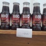 A display of BBQ sauce bottles on a shelf.