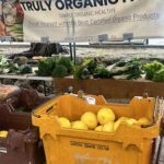 A display of fresh fruits and vegetables, including lemons, is available for purchase.