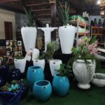 A display of white and blue vases with plants and flowers.