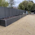 A garden with a fence and a sign.