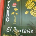 A green sign with yellow flowers and the words "El Panteno" written on it.