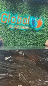 A green wall with a sign that says Groodi Academy.