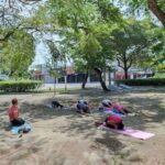 A group of people are practicing yoga in a park.
