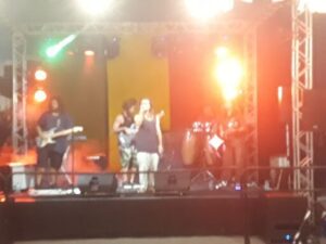 A group of people are singing on stage in front of a crowd.