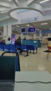 A group of people are sitting in a waiting area, waiting for their turn to be served.