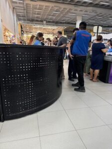 A group of people are standing around a counter, engaged in conversation.