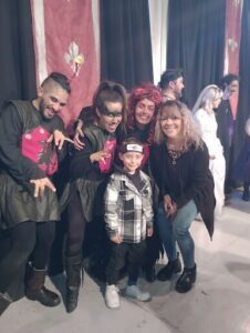 A group of people, including a young boy, pose for a photo on stage.