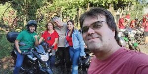 A group of people posing for a picture in front of a forest.
