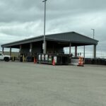 A large building with a metal roof and a parking lot.