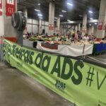 A large green sign with white letters reads "Ferias da Ads".