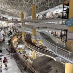 A large shopping mall with a spiral walkway and a yellow and white color scheme.