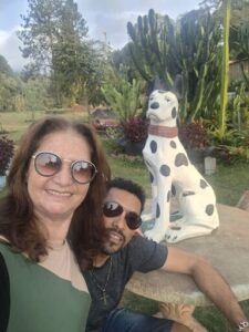 A man and a woman pose for a picture in front of a Dalmatian statue.