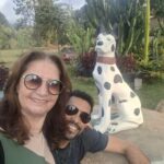 A man and woman pose for a picture in front of a Dalmatian statue.