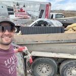 A man is standing next to a truck with a Canadian flag on it.