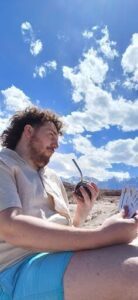 A man with a beard and mustache is holding a pipe and a small container.