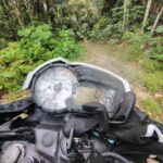 A motorcycle with a black glove on the handlebars.