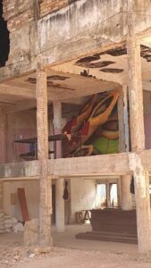 A painting of a bird is displayed on the wall of a building.