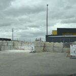 A parking lot with a sign that says "no parking" and a fence.