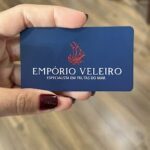 A person is holding a blue card with a sailboat on it.