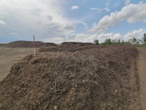 A pile of wood chips and branches in a field.
