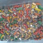 A plastic container filled with a variety of dog food, including seeds, nuts, and corn.