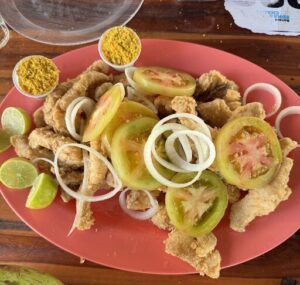 A plate of food with tomatoes, onions, and fish.