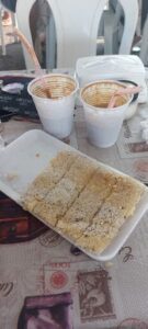 A plate of food with two cups of drinks on the table.