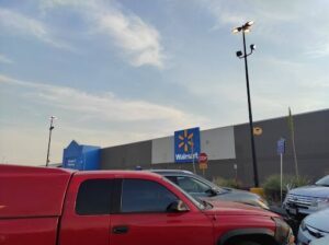 A red truck is parked in front of a Walmart store.
